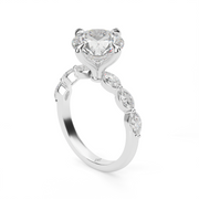 White Gold Round Shape Diamond Side Stone Engagement Ring With Shared Prong Setting.
